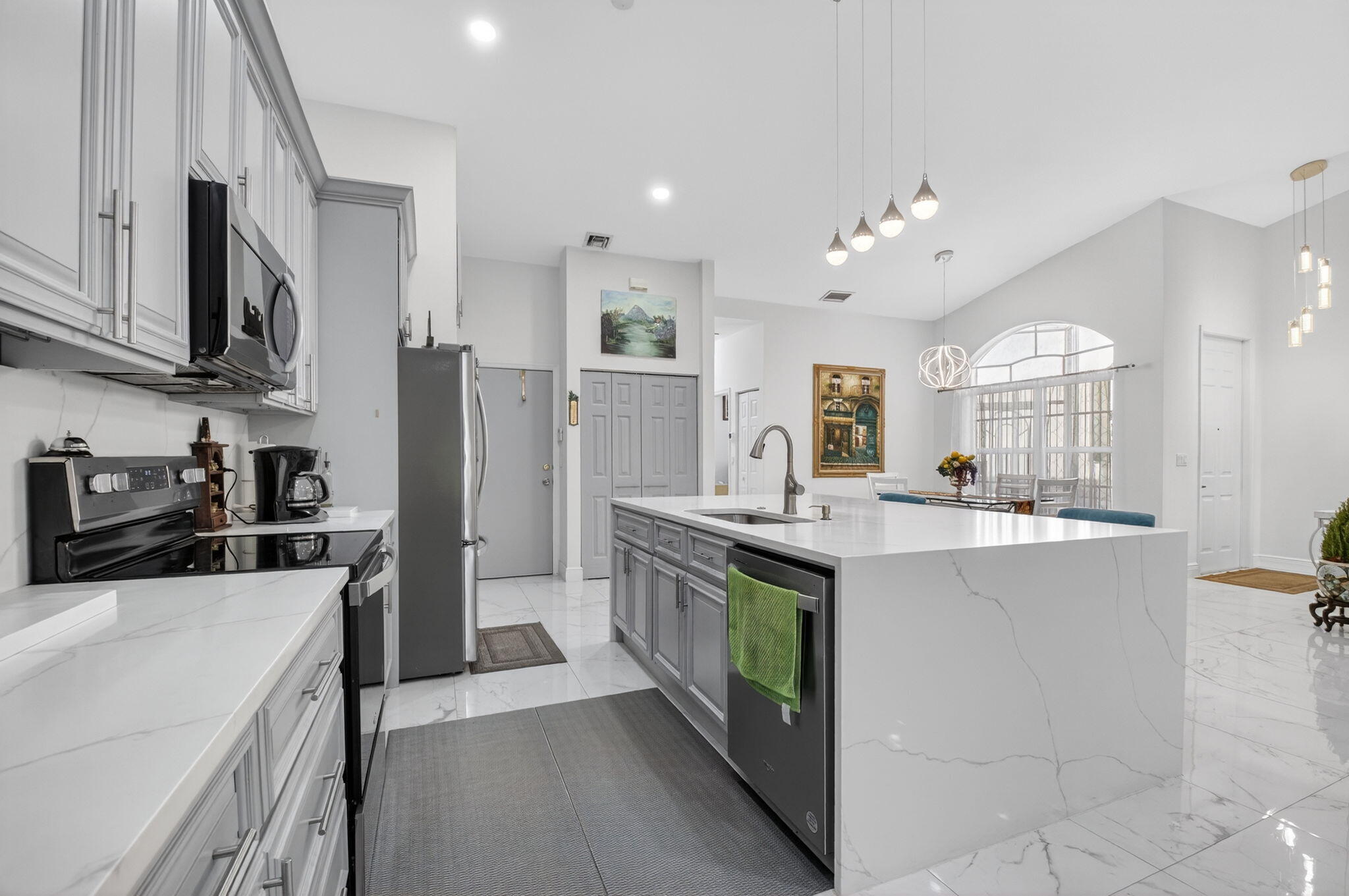 6247 Heliconia Road Delray Beach, FL 33484 - Photo 7 of 25 a kitchen with stainless steel appliances a sink stove and refrigerator