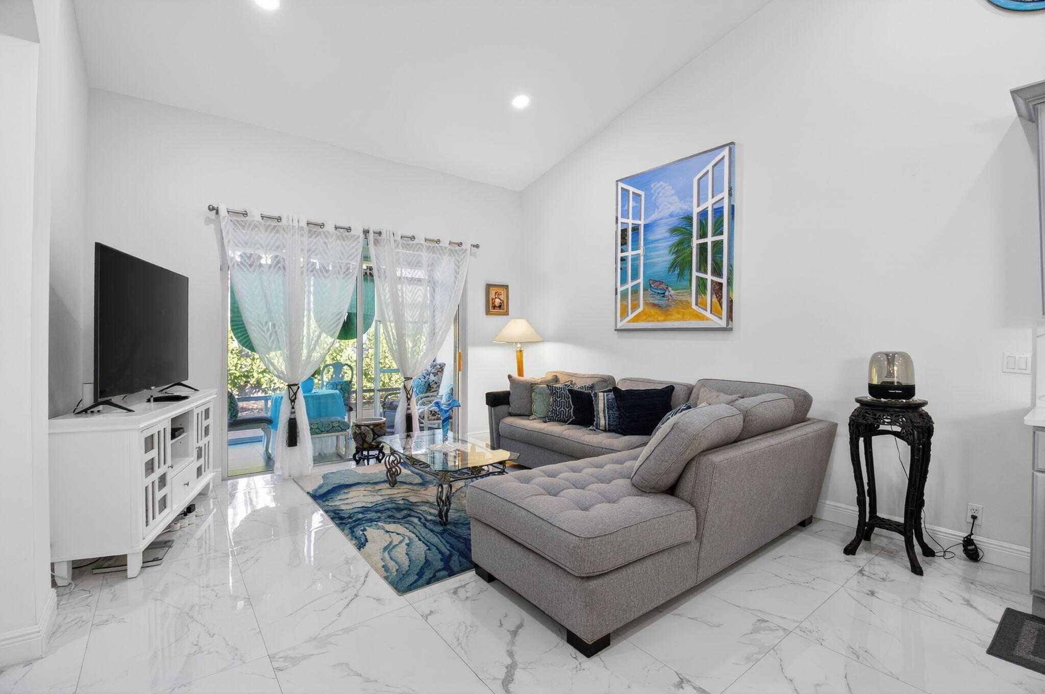 6247 Heliconia Road Delray Beach, FL 33484 - Photo 8 of 25 a living room with furniture a flat screen tv and a floor to ceiling window