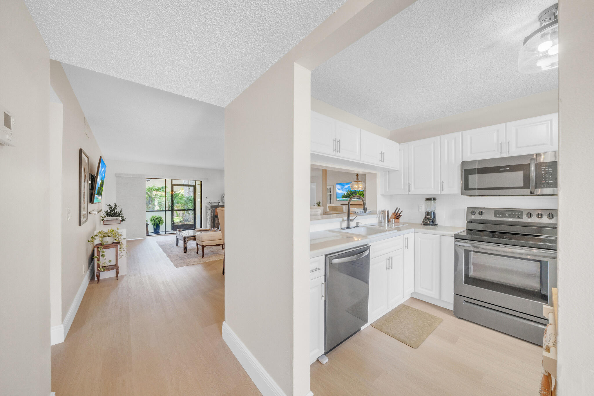 22136 Palms Way, Unit 103 Boca Raton, FL 33433 - Photo 4 of 42 a kitchen with white cabinets and stainless steel appliances