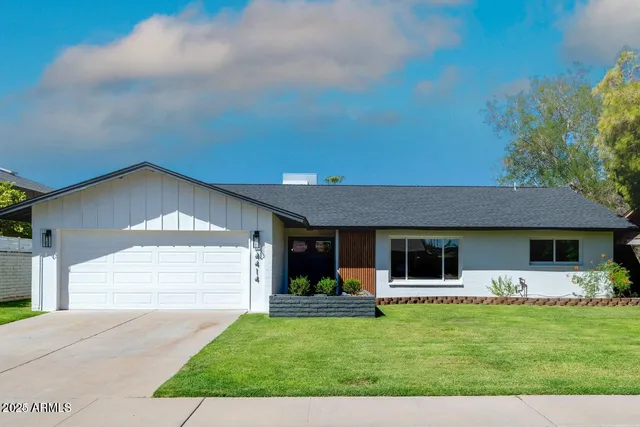 a front view of a house with a garden and yard