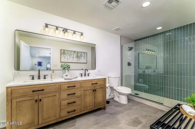 a bathroom with a double vanity sink mirror and toilet