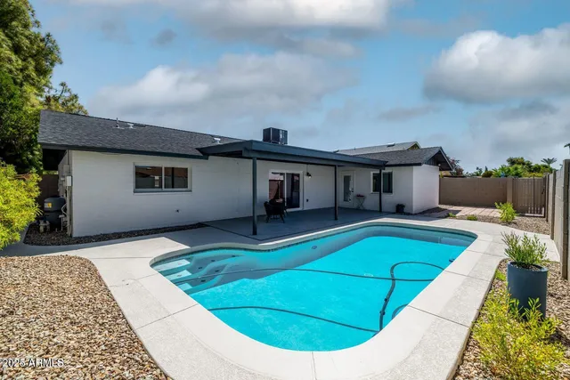 a view of a house with pool and a yard