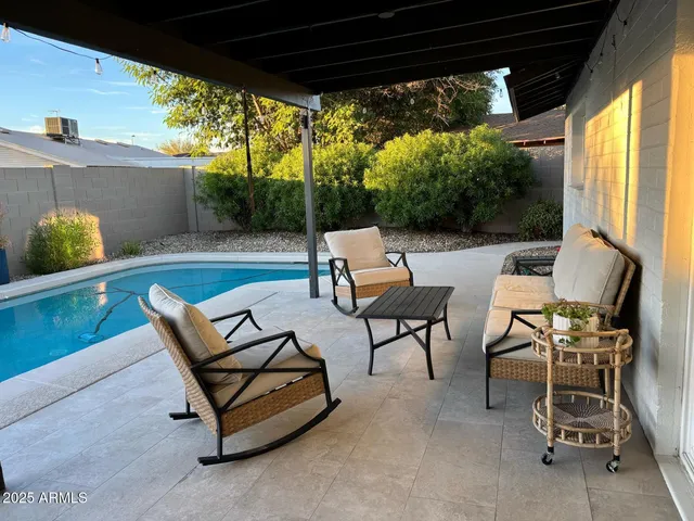 a view of patio with table and chairs and floor to ceiling window