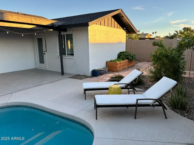 a backyard of a house with table and chairs