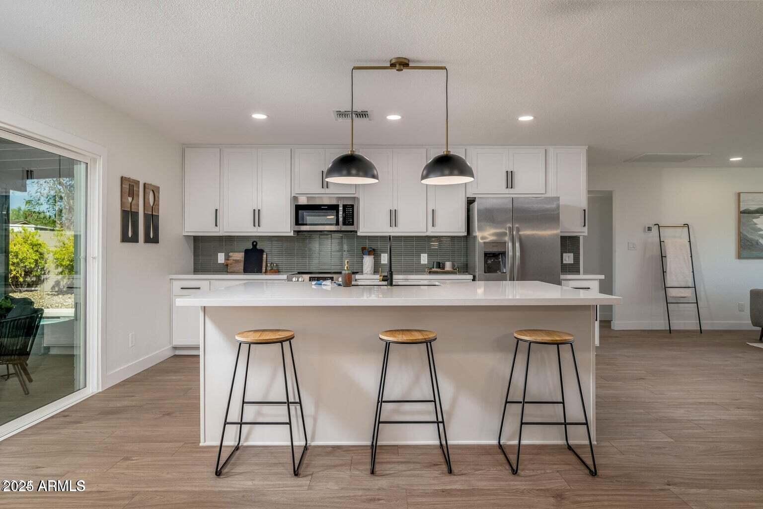 4414 South Terrace Road Tempe, AZ 85282 - Photo 6 of 24 a kitchen with stainless steel appliances kitchen island granite countertop a table chairs sink and cabinets