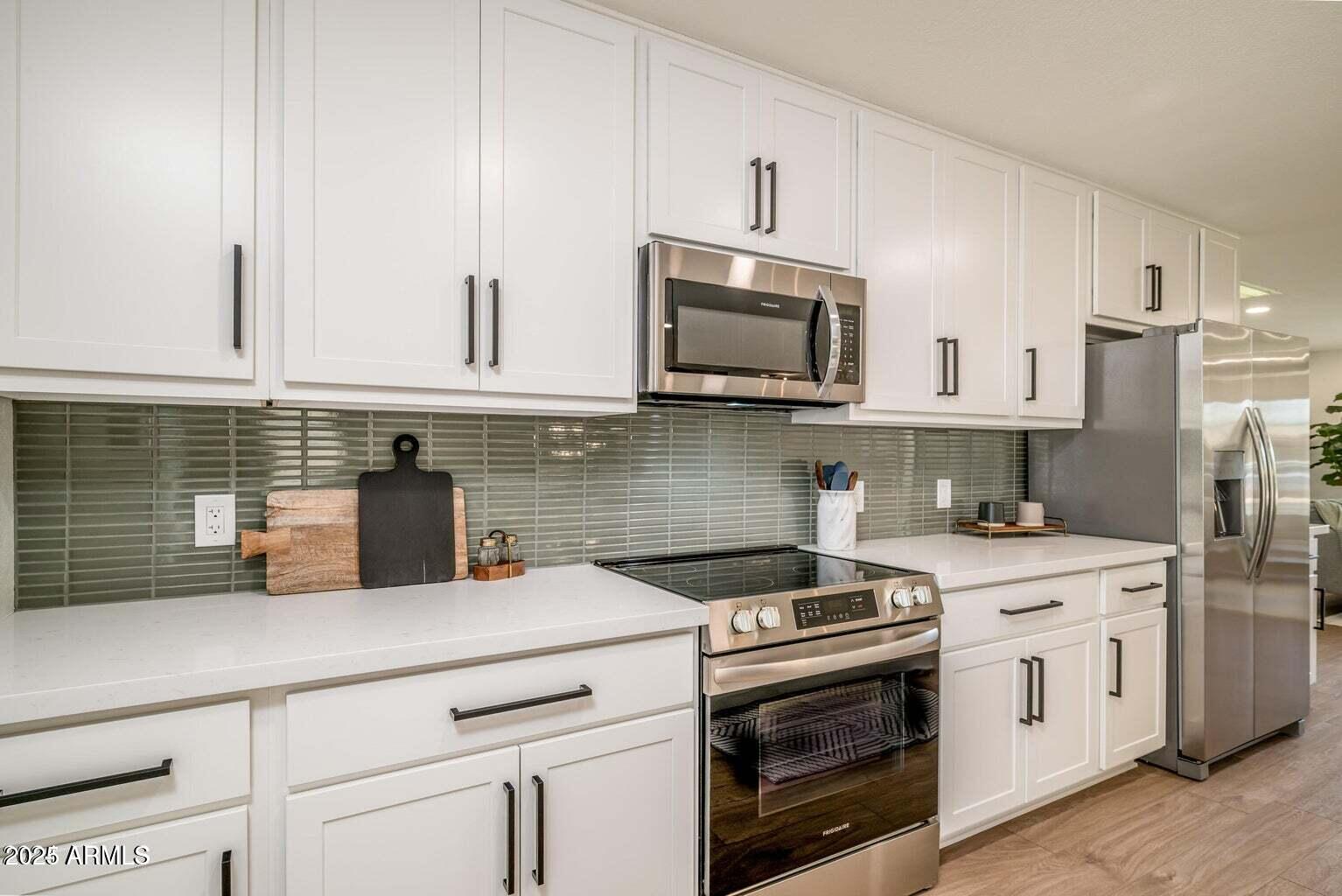 4414 South Terrace Road Tempe, AZ 85282 - Photo 7 of 24 a kitchen with stainless steel appliances granite countertop white cabinets a sink a stove a refrigerator and white cabinets