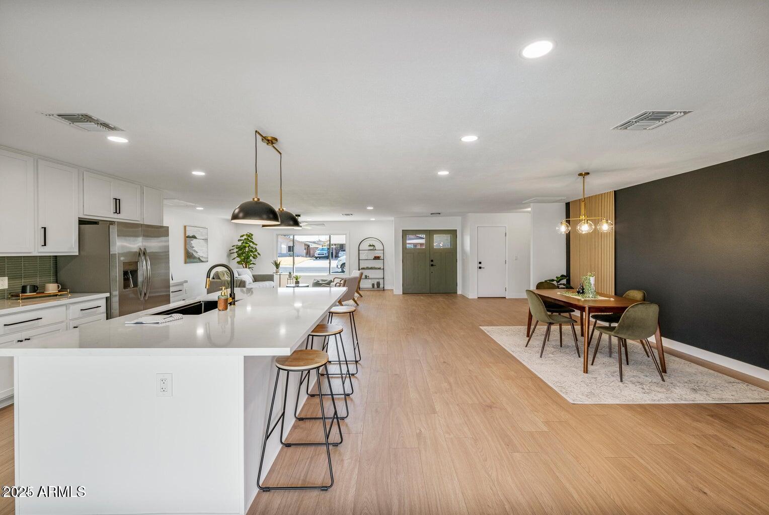 4414 South Terrace Road Tempe, AZ 85282 - Photo 9 of 24 a kitchen with stainless steel appliances granite countertop a stove top oven a sink dishwasher a dining table and chairs with wooden floor