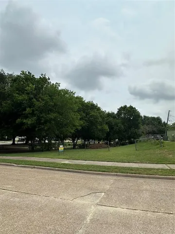 a view of a tennis ground with trees in the background