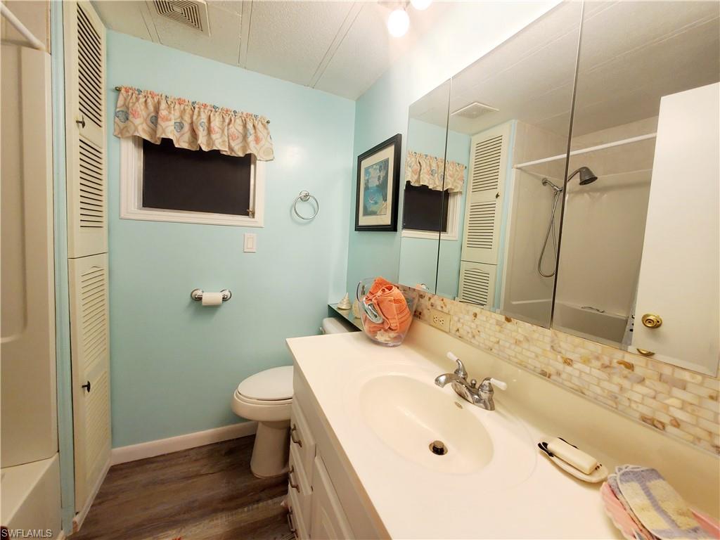 91 Enchanting Boulevard, Unit E91 Naples, FL 34112 - Photo 21 of 23 a bathroom with a sink and a mirror