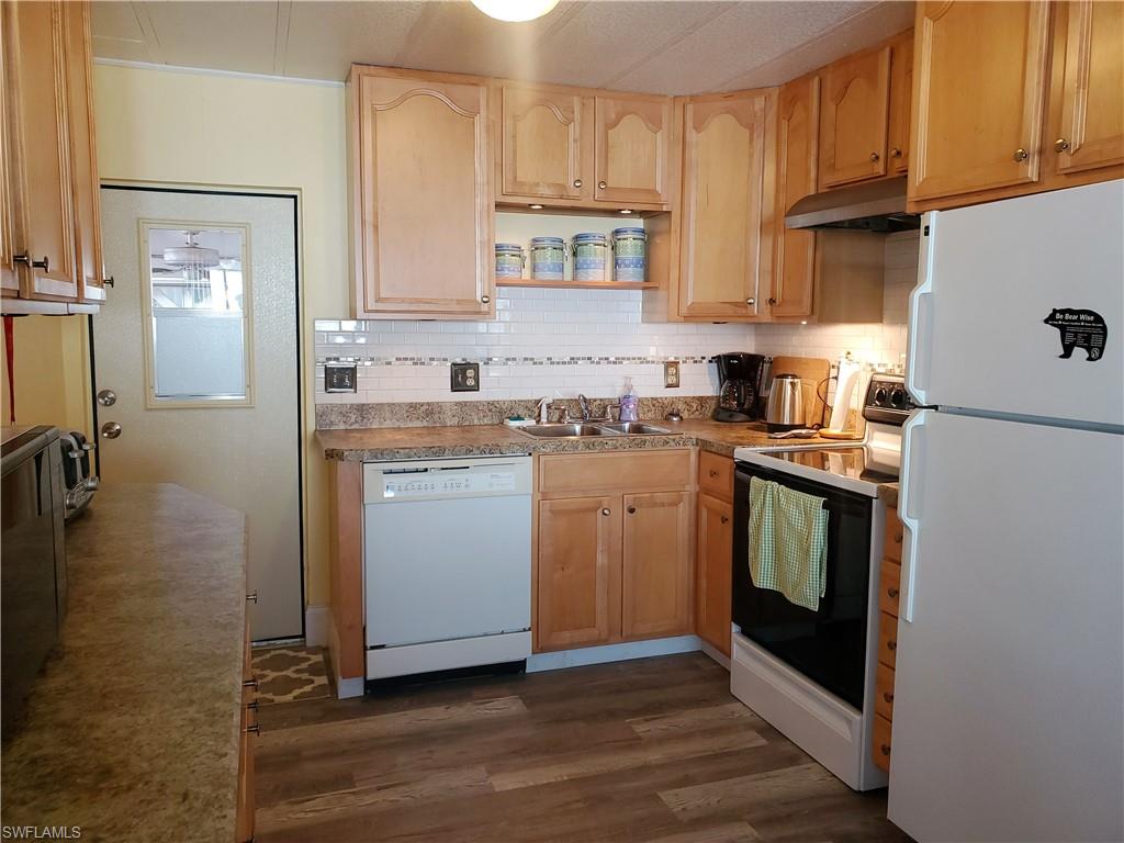 91 Enchanting Boulevard, Unit E91 Naples, FL 34112 - Photo 5 of 23 a kitchen with a stove top oven sink and cabinets