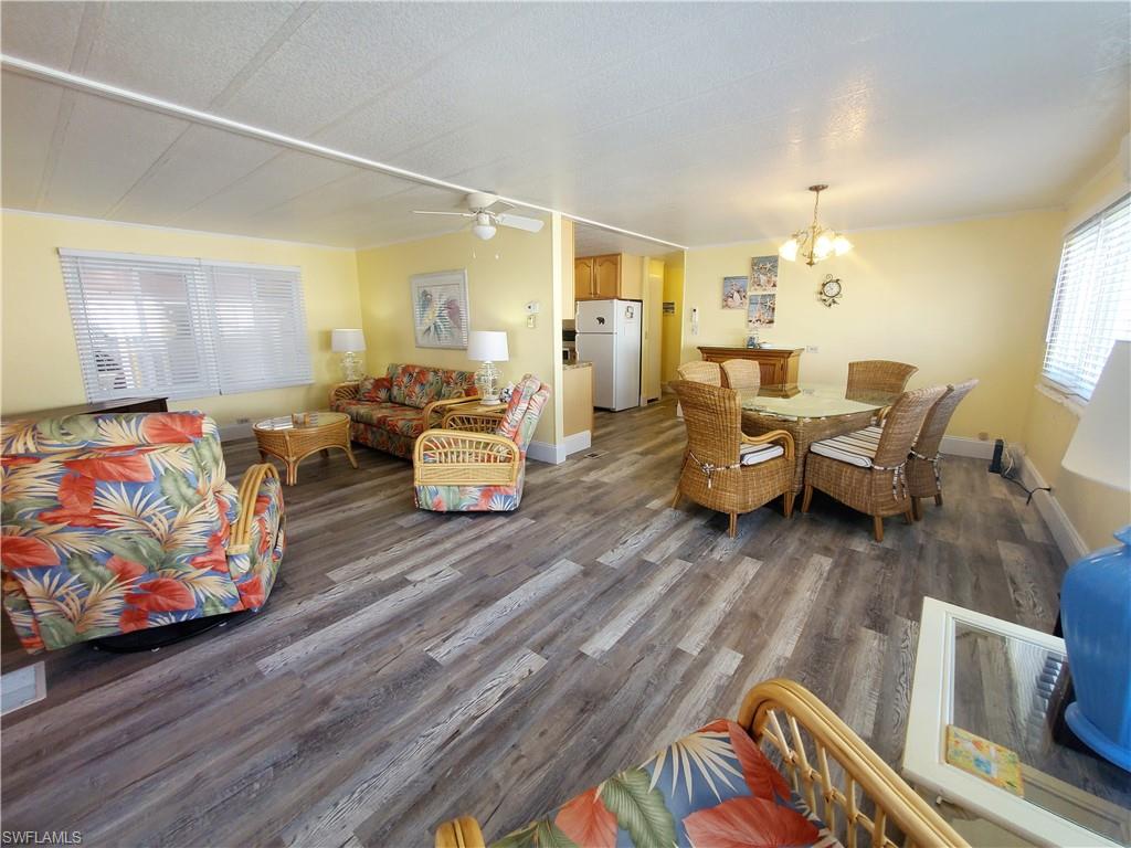 91 Enchanting Boulevard, Unit E91 Naples, FL 34112 - Photo 7 of 23 a living room with furniture and paintings on the wall