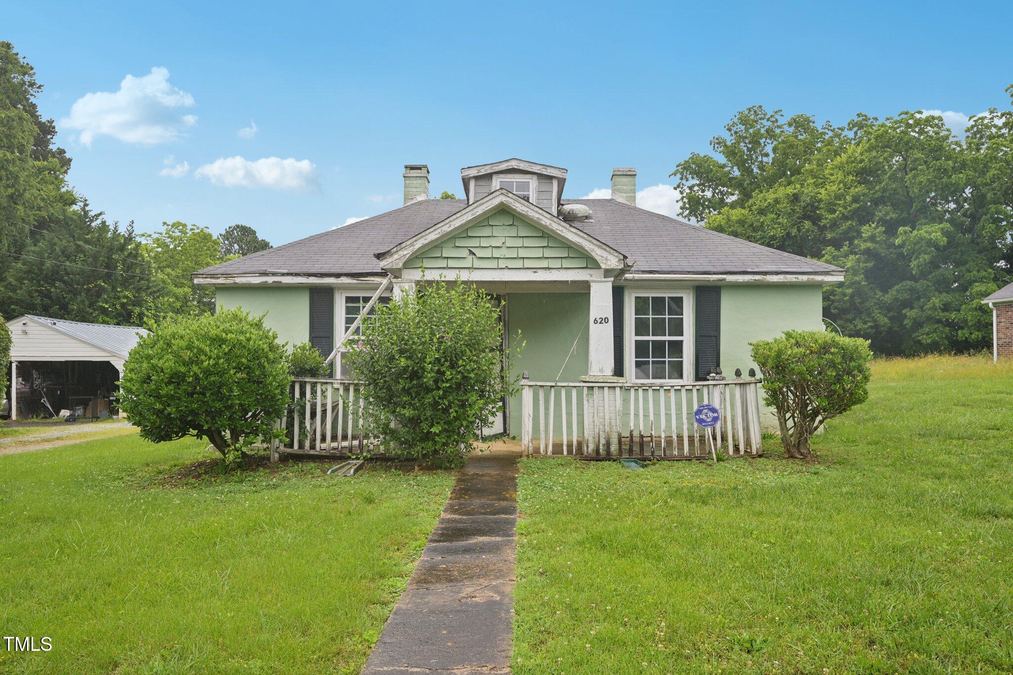 a front view of a house with a garden and yard