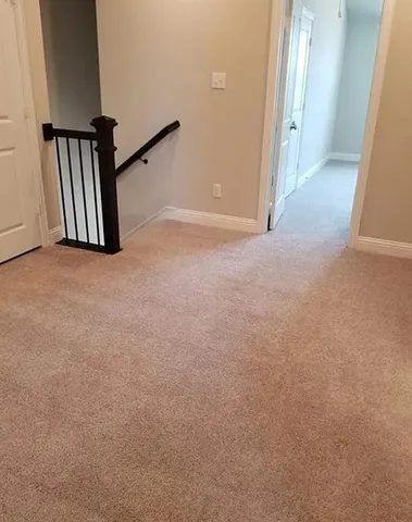 an empty room with staircase and mirror