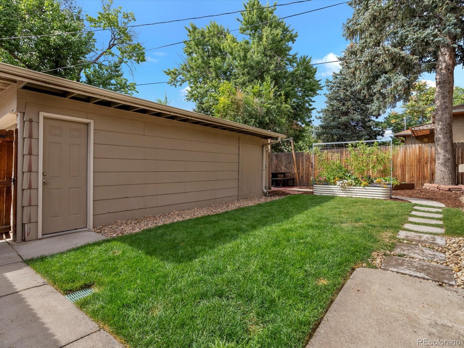 4963 North Harlan Street Wheat Ridge, CO 80033 - Photo 31 of 42 a view of a backyard with potted plants and large tree
