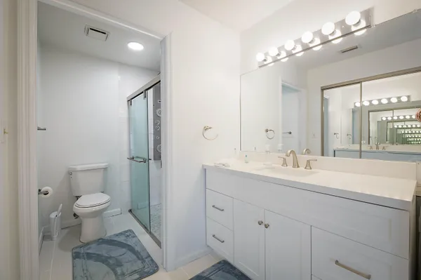 a spacious bathroom with a toilet sink and mirror