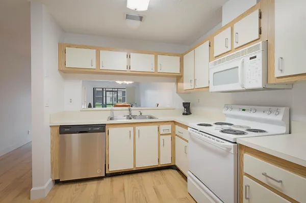 a kitchen with stainless steel appliances granite countertop a sink and cabinets with wooden floor
