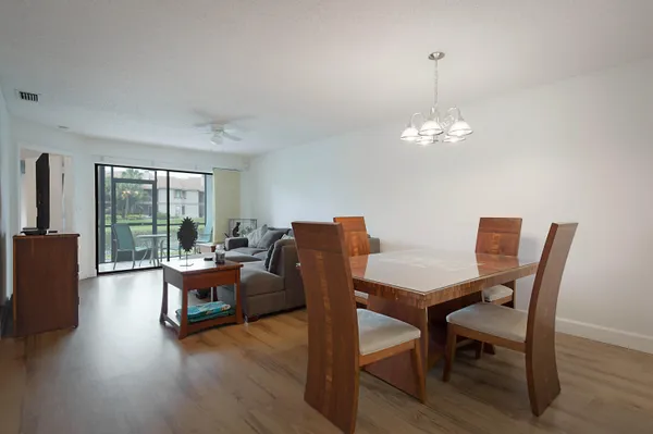 a view of a dining room with furniture wooden floor and chandelier