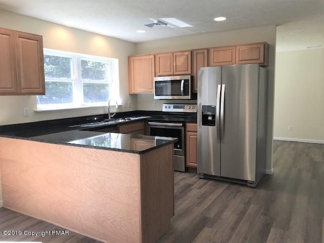 6305 Laurel Road Pocono Summit, PA 18346 - Photo 4 of 13 a kitchen with granite countertop a refrigerator and a sink