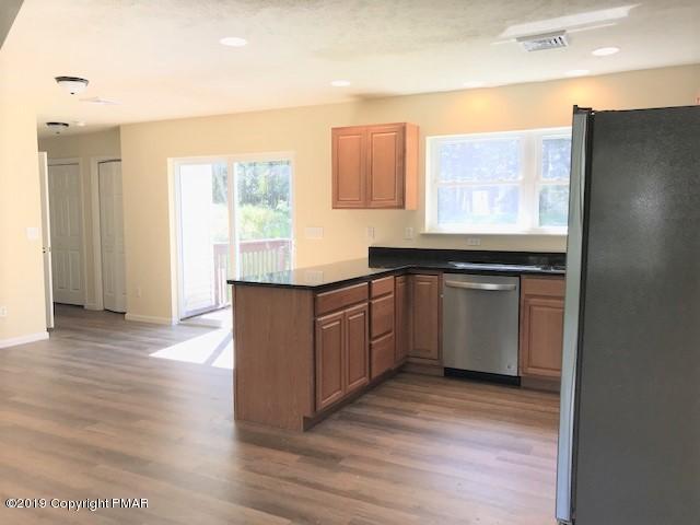 6305 Laurel Road Pocono Summit, PA 18346 - Photo 5 of 13 a kitchen with stainless steel appliances granite countertop a stove a sink and a refrigerator