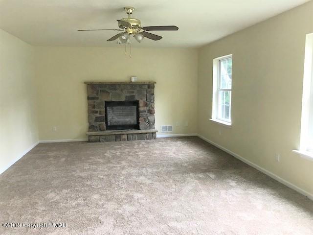 6305 Laurel Road Pocono Summit, PA 18346 - Photo 7 of 13 an empty room with windows and fireplace
