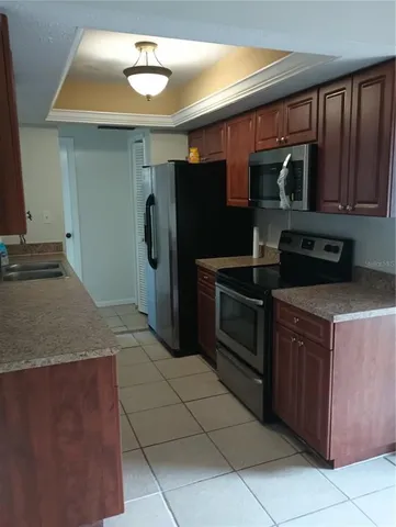 a kitchen with stainless steel appliances granite countertop a refrigerator and a stove