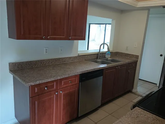 a kitchen with granite countertop a sink and cabinets