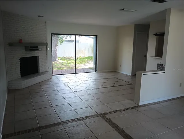 a view of a livingroom with an empty space and a fireplace