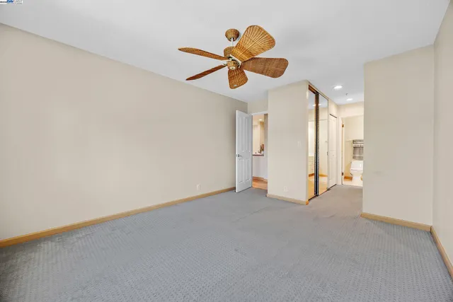 a view of an empty room with a ceiling fan