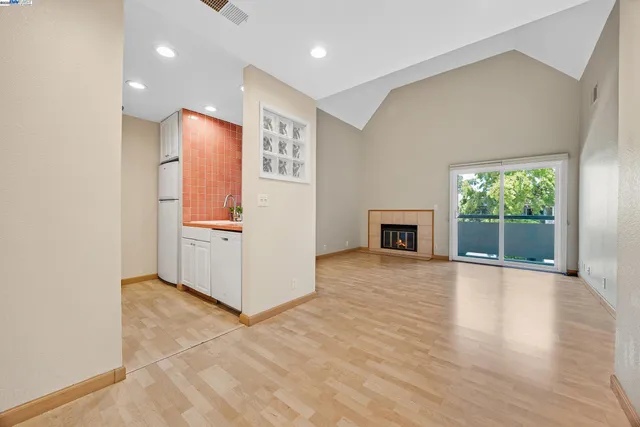 a view of empty room with wooden floor and fireplace