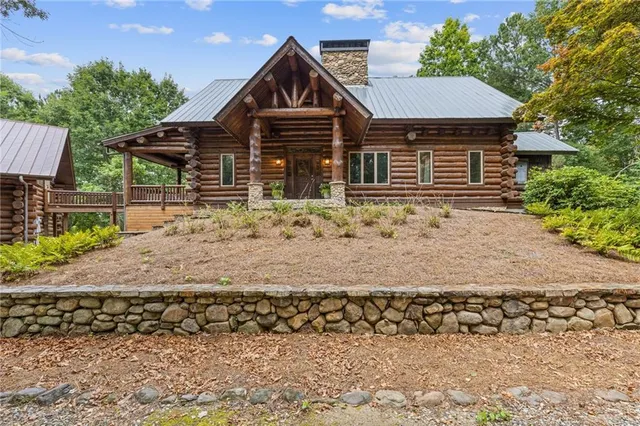 a front view of a house with a yard covered with trees
