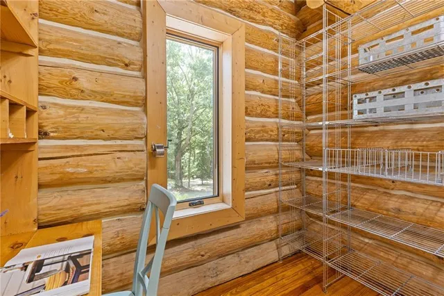a view of an empty room with kitchen view and a window