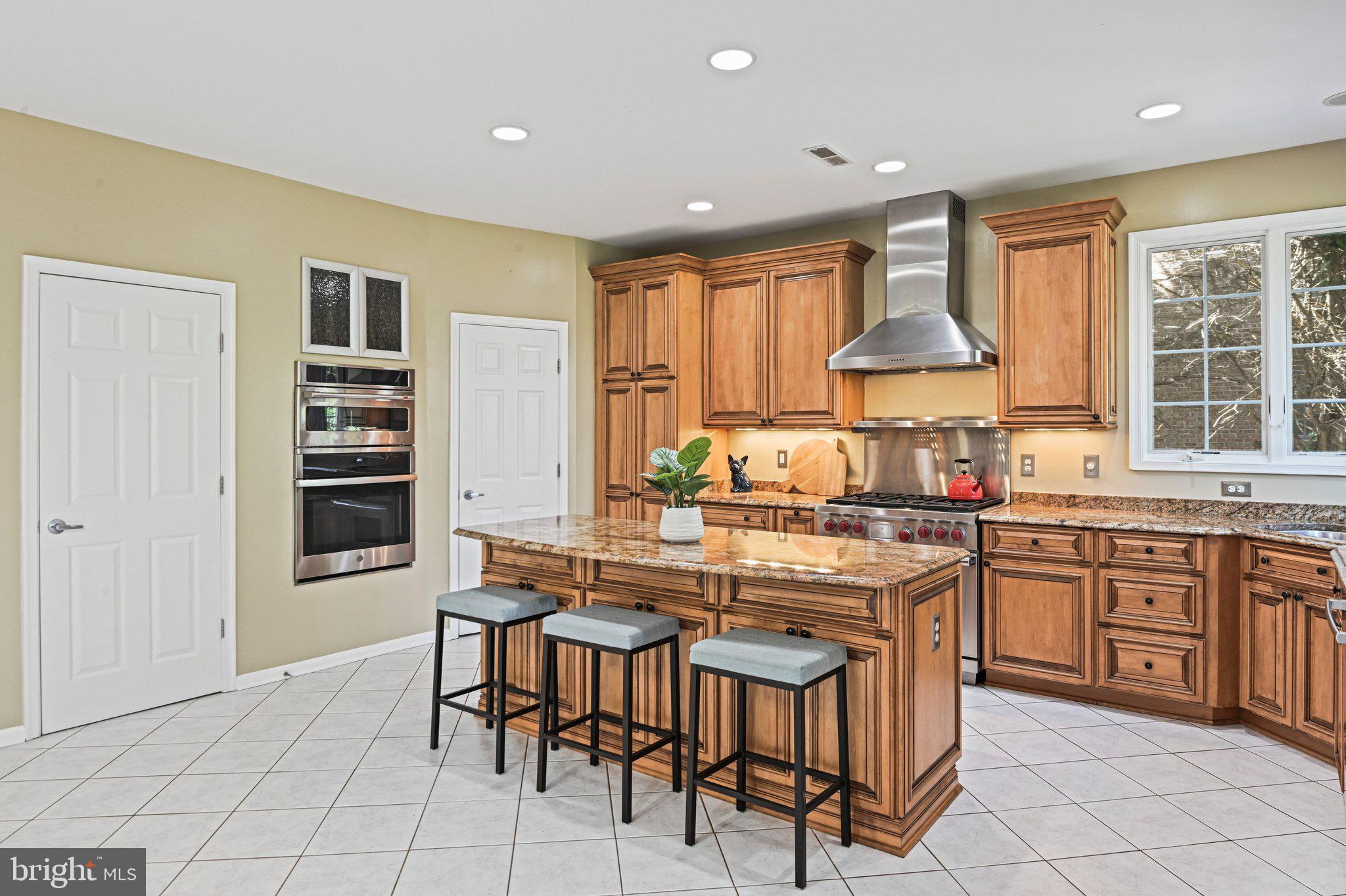 1831 Beulah Road Vienna, VA 22182 - Photo 12 of 96 a kitchen with stainless steel appliances granite countertop a stove top oven a sink dishwasher a dining table and chairs with wooden floor