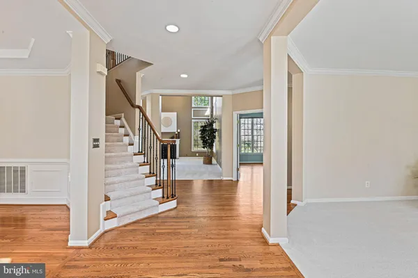 a kitchen with stainless steel appliances granite countertop a stove top oven a sink dishwasher a dining table and chairs with wooden floor