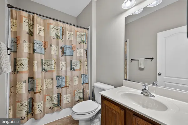 a view of a hallway with a livingroom and a bathroom with toilet