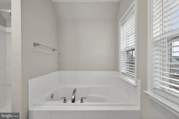 a bedroom with a large bed chandelier and a window
