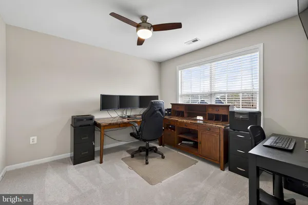 a view of a workspace with furniture and a window