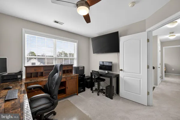 a view of a workspace with furniture and a flat screen tv