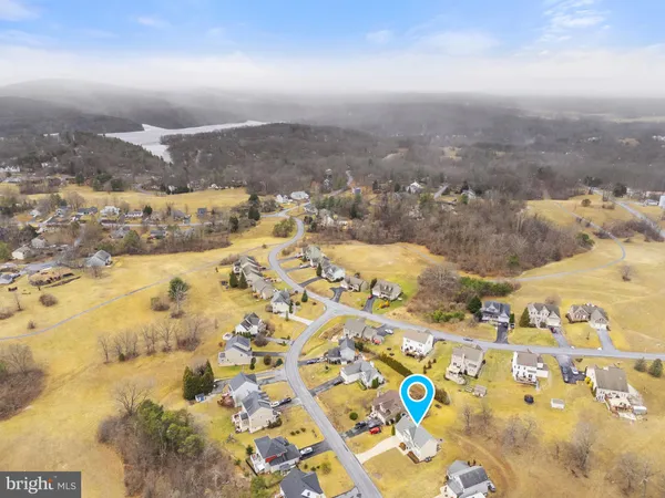 a living room with furniture kitchen area and a wooden floor