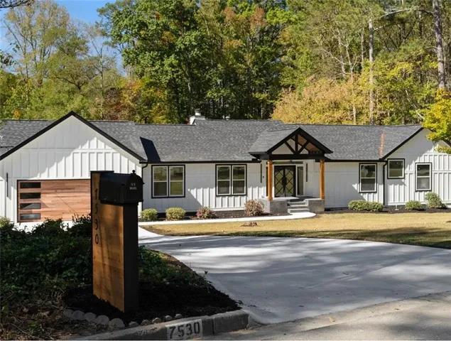 a front view of a house with swimming pool and trees
