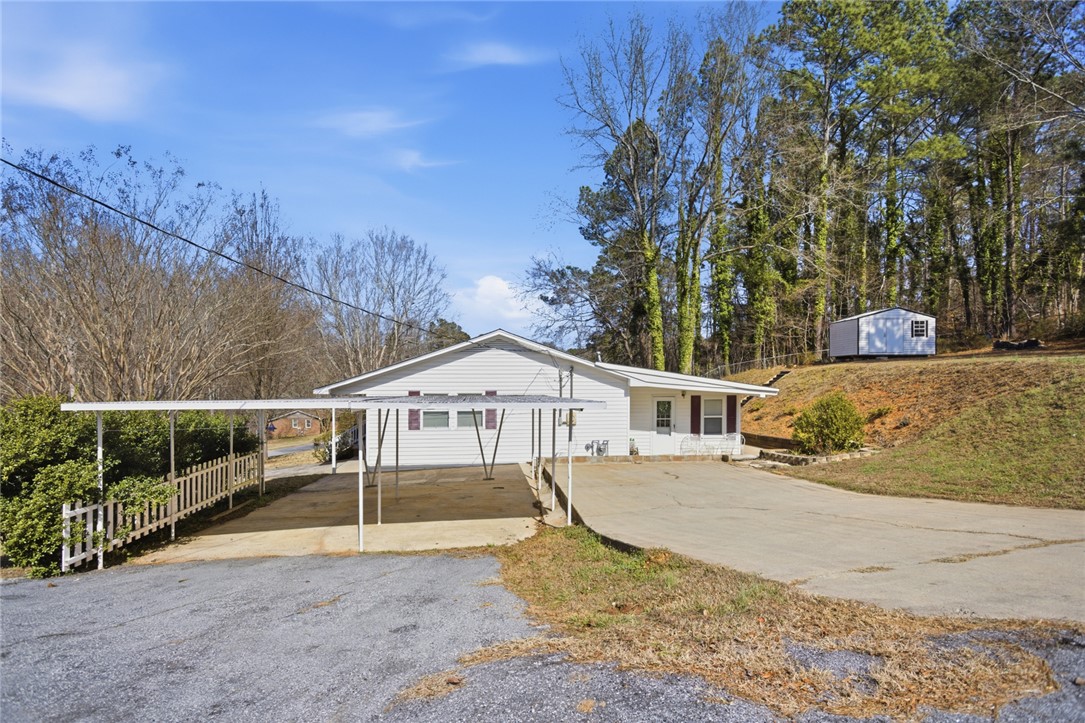 108 Hodge Street Abbeville, SC 29620 - Photo 25 of 39 A quaint residence featuring a convenient carport and additional outdoor storage.
