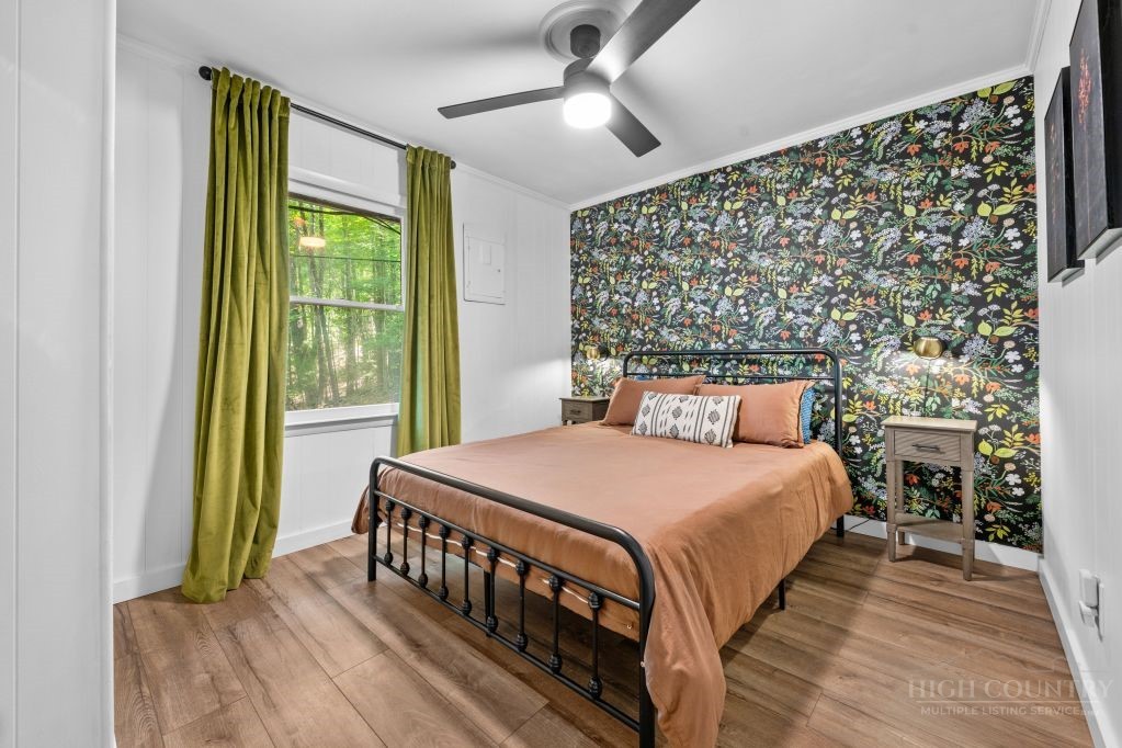 216 Saddle Lane Deep Gap, NC 28618 - Photo 13 of 44 a bedroom with a bed and a chandelier