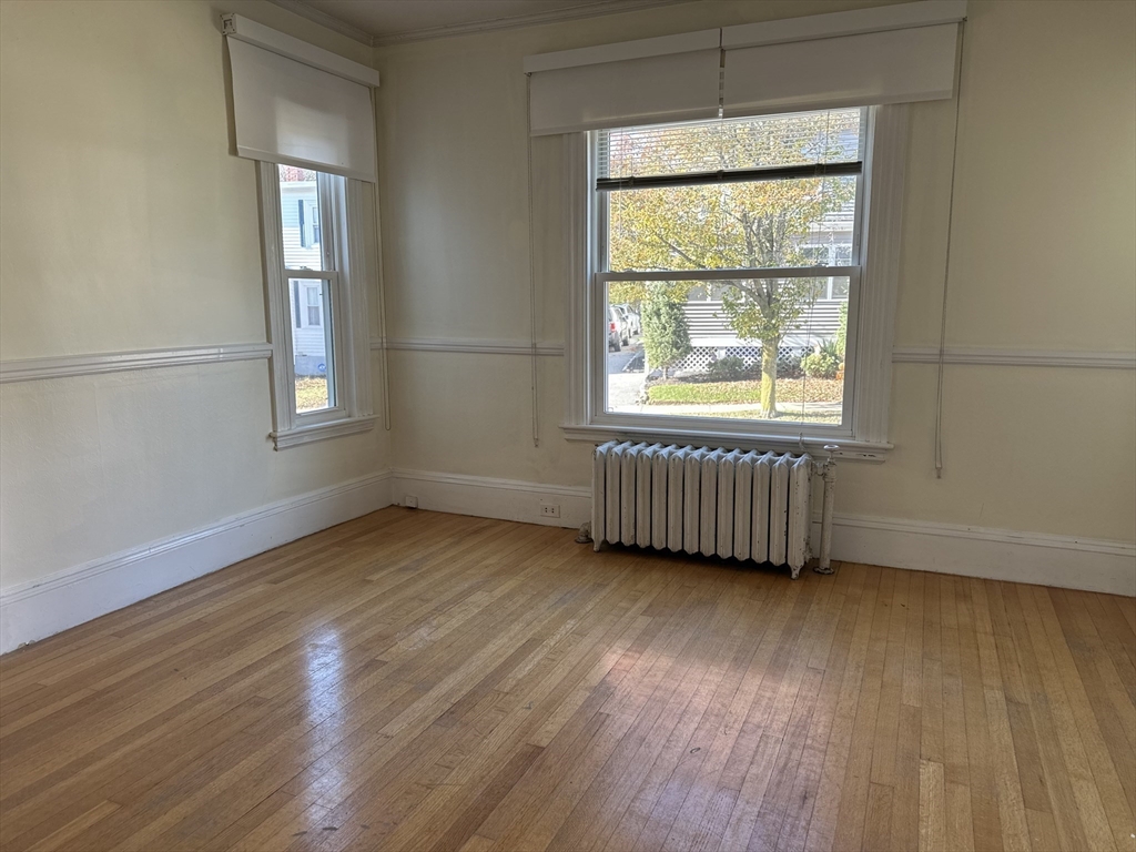 90 Russell Street, Unit 90 Melrose, MA 02176 - Photo 2 of 9 an empty room with wooden floor and windows