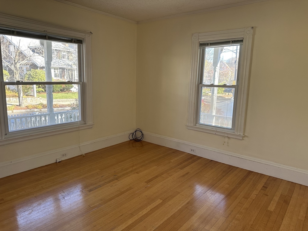 90 Russell Street, Unit 90 Melrose, MA 02176 - Photo 3 of 9 a view of an empty room with wooden floor and a window