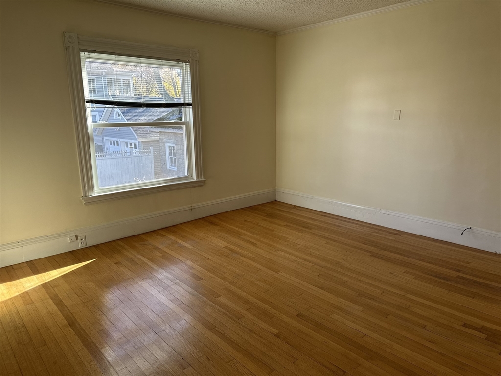 90 Russell Street, Unit 90 Melrose, MA 02176 - Photo 4 of 9 a view of an empty room with wooden floor and a window