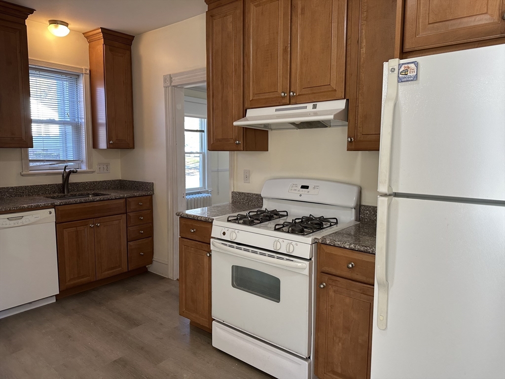 90 Russell Street, Unit 90 Melrose, MA 02176 - Photo 6 of 9 a kitchen with a stove cabinets and a refrigerator