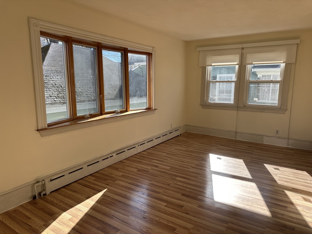 90 Russell Street, Unit 90 Melrose, MA 02176 - Photo 9 of 9 a view of an empty room with wooden floor and a window