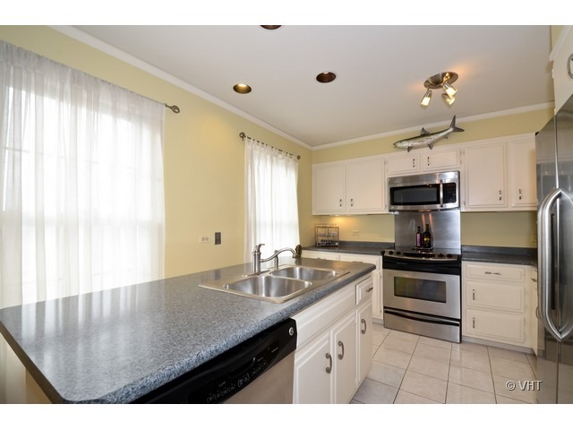 15 Landmark Street Northfield, IL 60093 - Photo 5 of 22 a kitchen with stainless steel appliances granite countertop a sink a stove and cabinets