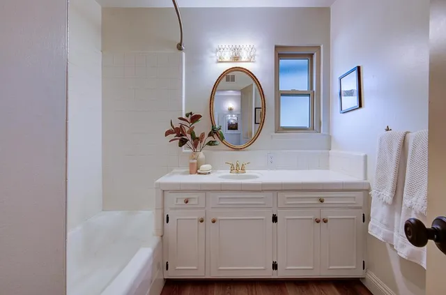 a bathroom with a sink a mirror and a window