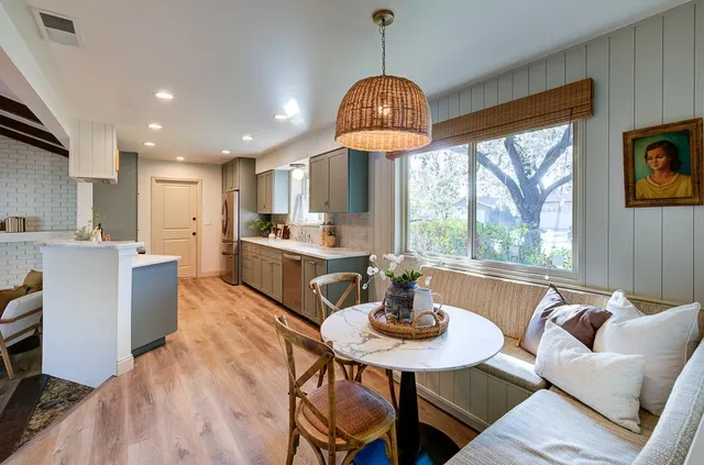 a view of a dining room with furniture a chandelier and wooden floor