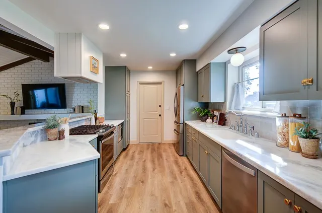 a large kitchen with stainless steel appliances lots of counter space and a sink